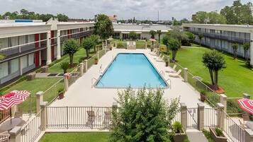 Alberca al aire libre, sombrillas en la alberca y camastros