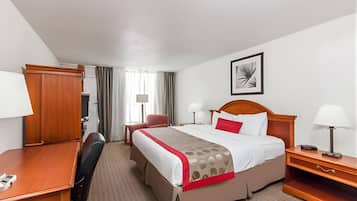 Escritorio, cortinas blackout y tabla de planchar con plancha