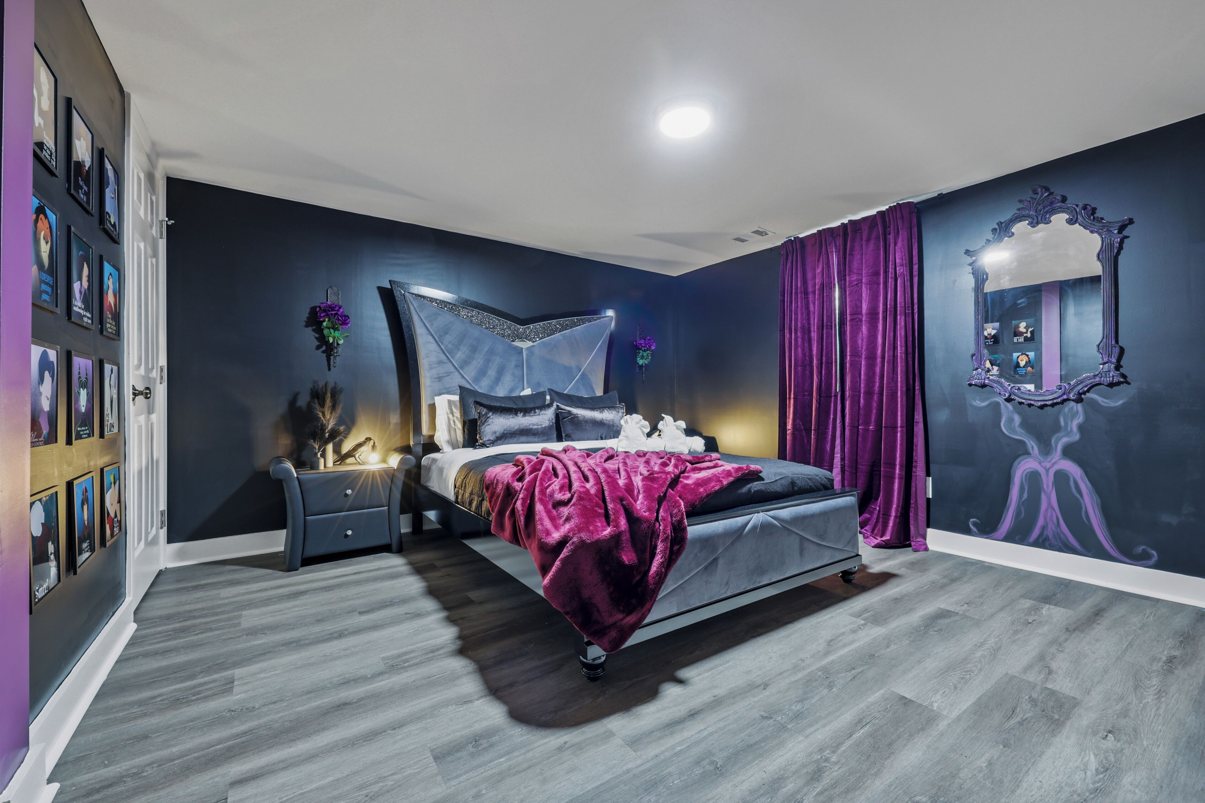 A bedroom with a bed, bedside tables, a dresser, a mirror, and a wall with framed pictures.