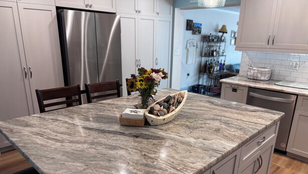 A kitchen with a marble countertop, stainless steel refrigerator, and white cabinets. - The Love Shack is a remodeled and roomy 2 BR house in fabulous St. Pete Beach (St. Pete Beach)