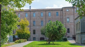 A brick building with multiple windows and a paved pathway leading to it. - Ca Moro - Rooms and Apartments (Rimini)