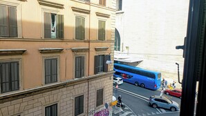 A multi-story building with a beige facade and shuttered windows. - Little Appartment (Rome)