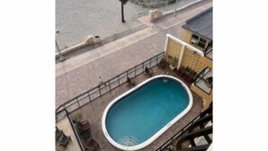 Una piscina con vista a la playa y palmeras.