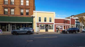 A street view with a row of buildings, including a restaurant with a sign that reads "SIRLOP".