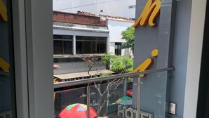 Ein Hotel mit Eingang, einer Glastür, einem Metallgeländer und Blick auf die Straße.