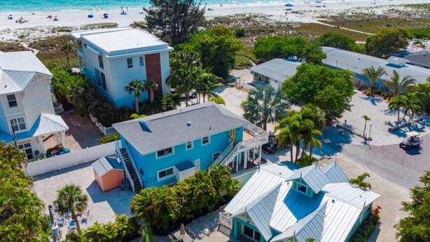 A coastal hotel with multiple buildings, a beach view, and a pool area.