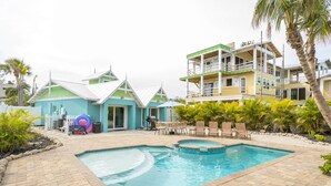 A swimming pool with a small waterfall feature, surrounded by a patio area with outdoor furniture.