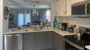 A modern kitchen with stainless steel appliances, white cabinets, and a central island.