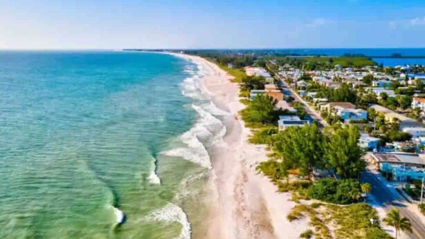 A coastal area with a beach, residential buildings, and clear blue water. - Waterfront 2BR on Manatee River Near Anna Maria Island (West Bradenton)