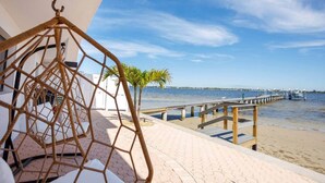A beachside view with a wooden deck, a rope hammock, and a clear blue sky. - Waterfront 2BR on Manatee River Near Anna Maria Island (West Bradenton)