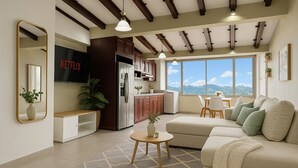 A modern living room with a sofa, coffee table, and dining area. There is a kitchen with a refrigerator and cabinets. A large window offers a view of the outdoors.