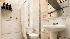 A modern bathroom with a toilet, sink, and shower.