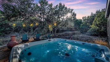 Een jacuzzi met een helder uitzicht op de omliggende bomen en een rustieke omgeving.
