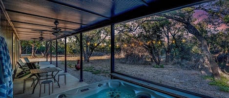 A hot tub area with a view of trees and a sunset.