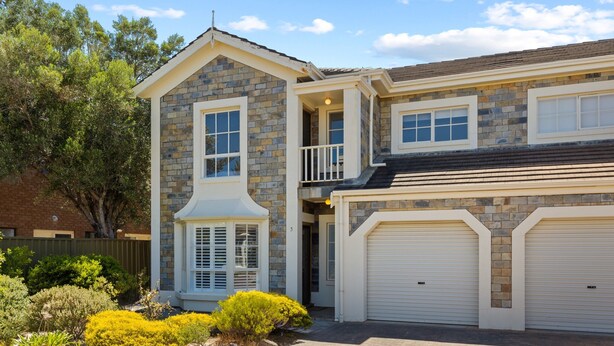 A two-story house with a stone facade, a balcony, and two garage doors. - Elegant 3-bed Home From Sunny Glenelg Beach (Adelaide)