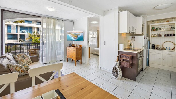 A modern apartment with a living room, dining area, kitchen, and balcony. - Great Location 1-bed With Pool (Sunshine Coast)