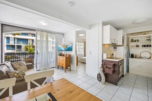 En modern lägenhet med vardagsrum, matplats, kök och balkong.
