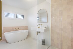 A modern bathroom with a freestanding bathtub, a glass-enclosed shower, and a vanity with a mirror. - Mediterranean Surfers Paradise Townhouse With BBQ (Gold Coast)