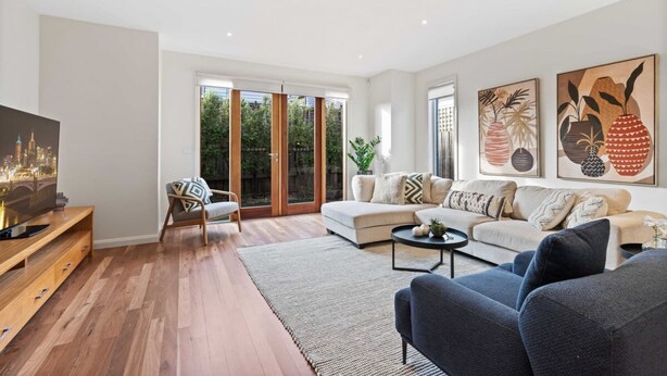 A modern living room with a sofa, armchairs, a coffee table, and artwork on the walls. - Chic 2-bed Home By Bustling Shops (Melbourne)