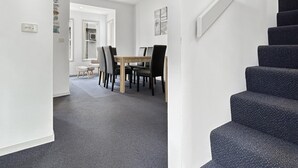 Un intérieur moderne comprenant un coin repas, un escalier et un couloir.
