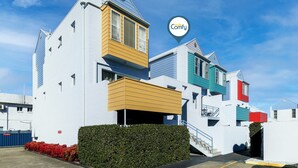Un bâtiment moderne doté d’un toit plat, de nombreux balcons et surplombant un ciel dégagé.