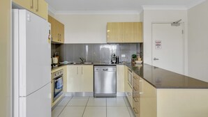A modern kitchen with a dishwasher, oven, and stainless steel appliances. - Bright 2-bed With Private Balcony & Serene View (Brisbane)