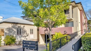 A residential building with a front entrance, a mailbox, and a staircase leading to a balcony. - Bright 2-bed With Private Balcony & Serene View (Brisbane)