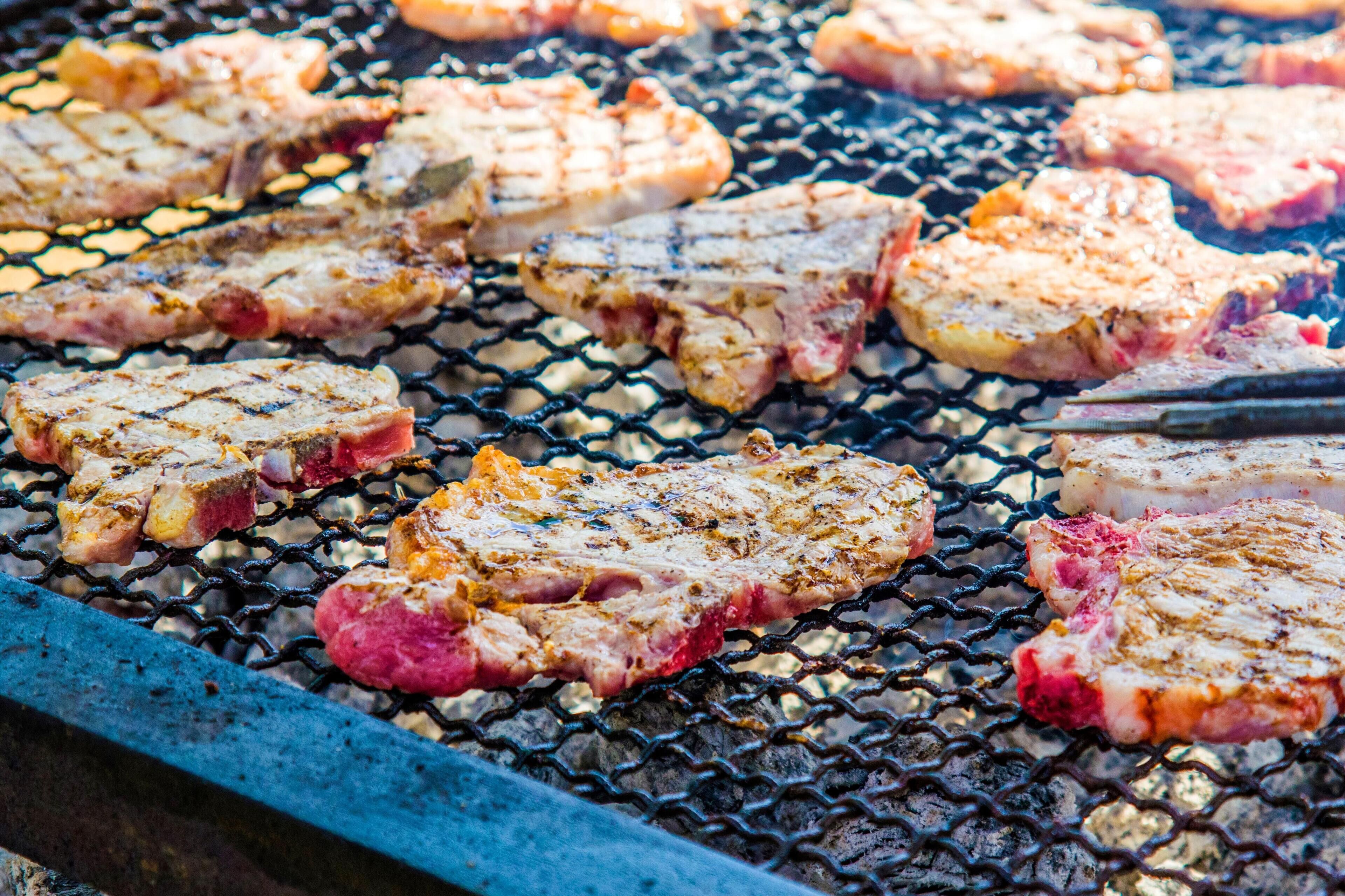 Egy grillsütő, amelyen több darab húst is sütnek.