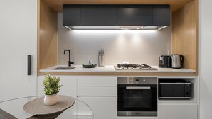 Una cocina moderna con horno empotrado, microondas, estufa a gas y un lavabo.