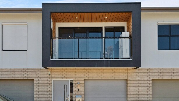A modern two-story house with a garage, a balcony, and a car parked in front. - Bright 2-bed Townhouse With Balcony & Garage (Adelaide)