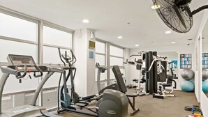 A gym with treadmills, elliptical machines, and weightlifting equipment. - City Centre Studio by Hyde Park (Sydney)
