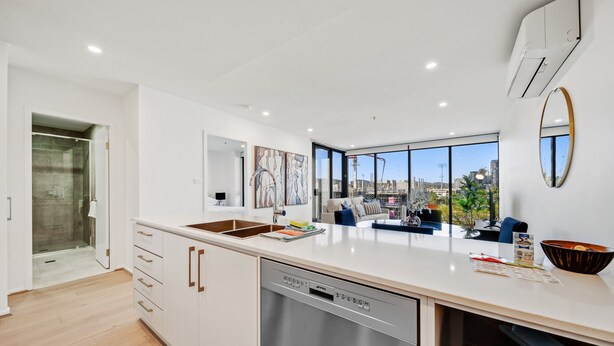 A modern kitchen with a dishwasher, a large window, and a view of the city. - Chic 1-bed With Sophisticated Decor, (Canberra)