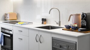 A modern kitchen with a built-in dishwasher, a toaster, and a coffee maker on the counter.
