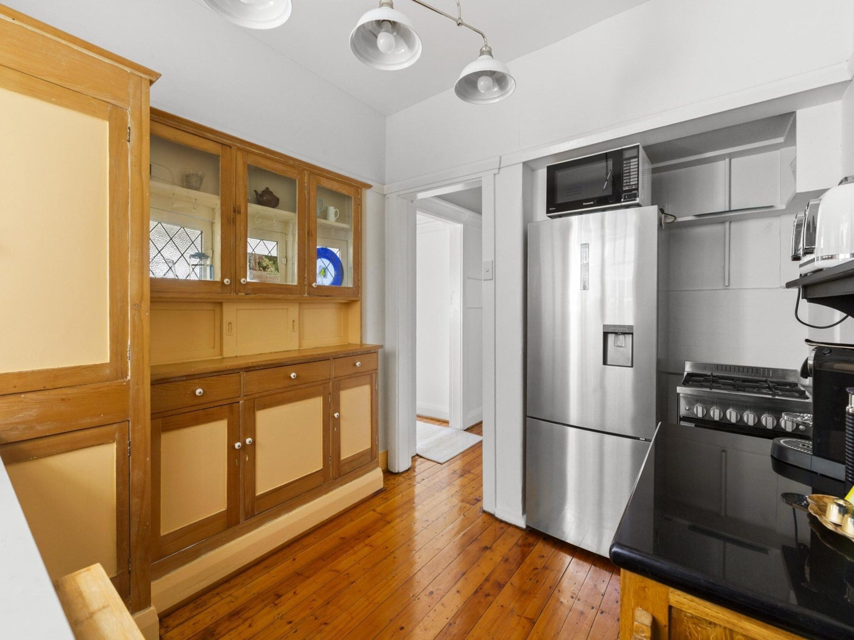 Una cocina con armarios de madera, electrodomésticos de acero inoxidable y una estufa negra.