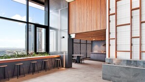 A modern interior with a bar area, seating, and a view of the cityscape.