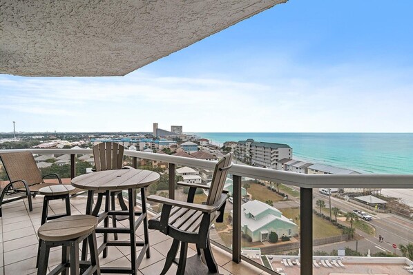 A balcony with a view of the ocean and a cityscape.