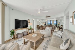 A spacious living room with a flat-screen TV, comfortable seating, and a view of the ocean. - 9th Floor! Awesome Views! Free Beach SRVC! Free Beach Bonfires M & Fri Nights (Miramar Beach)