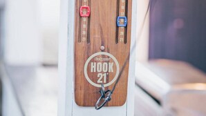 A wooden hook with numbered slots and a metal hook attached to it.