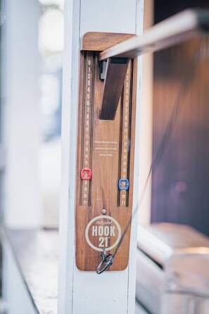 A wooden hook with numbered slots and a metal hook attached to it.