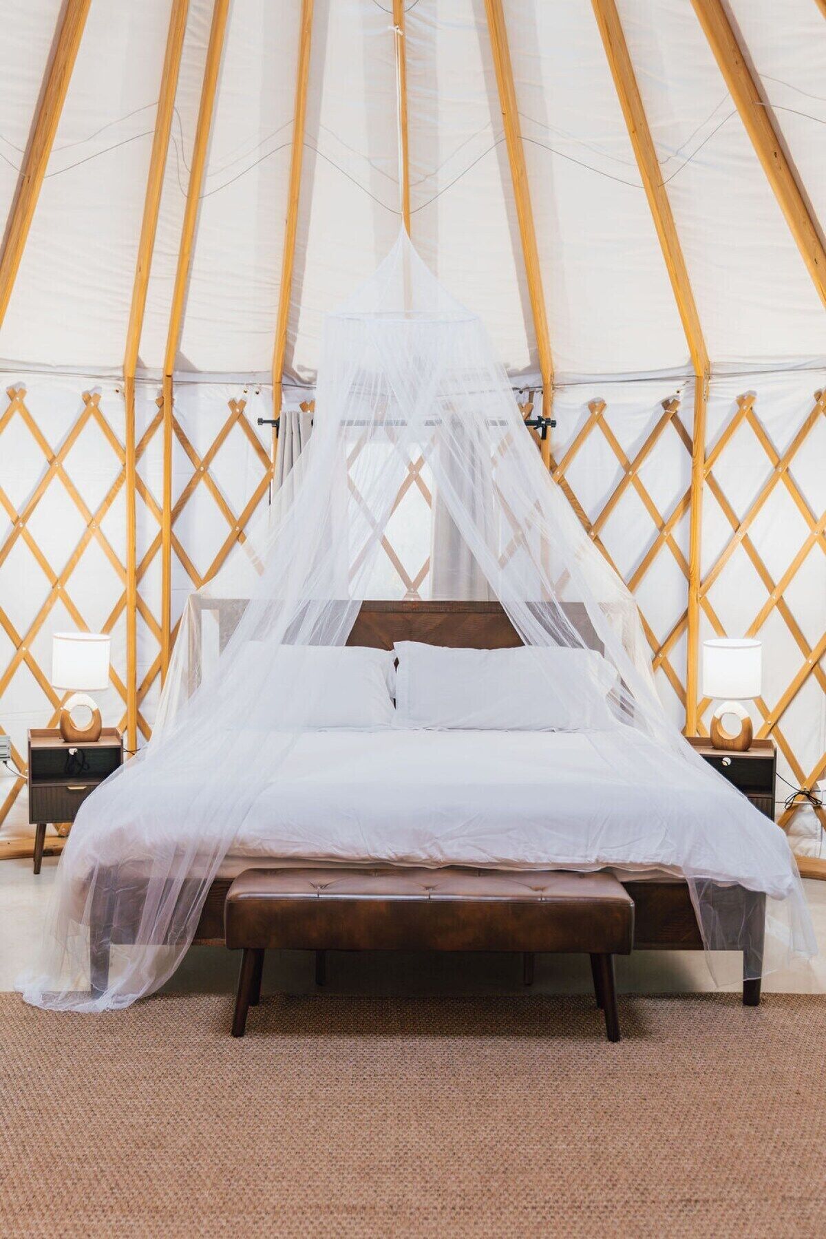 Ein Bett mit Baldachin in einer zeltähnlichen Konstruktion mit Gitterwand.