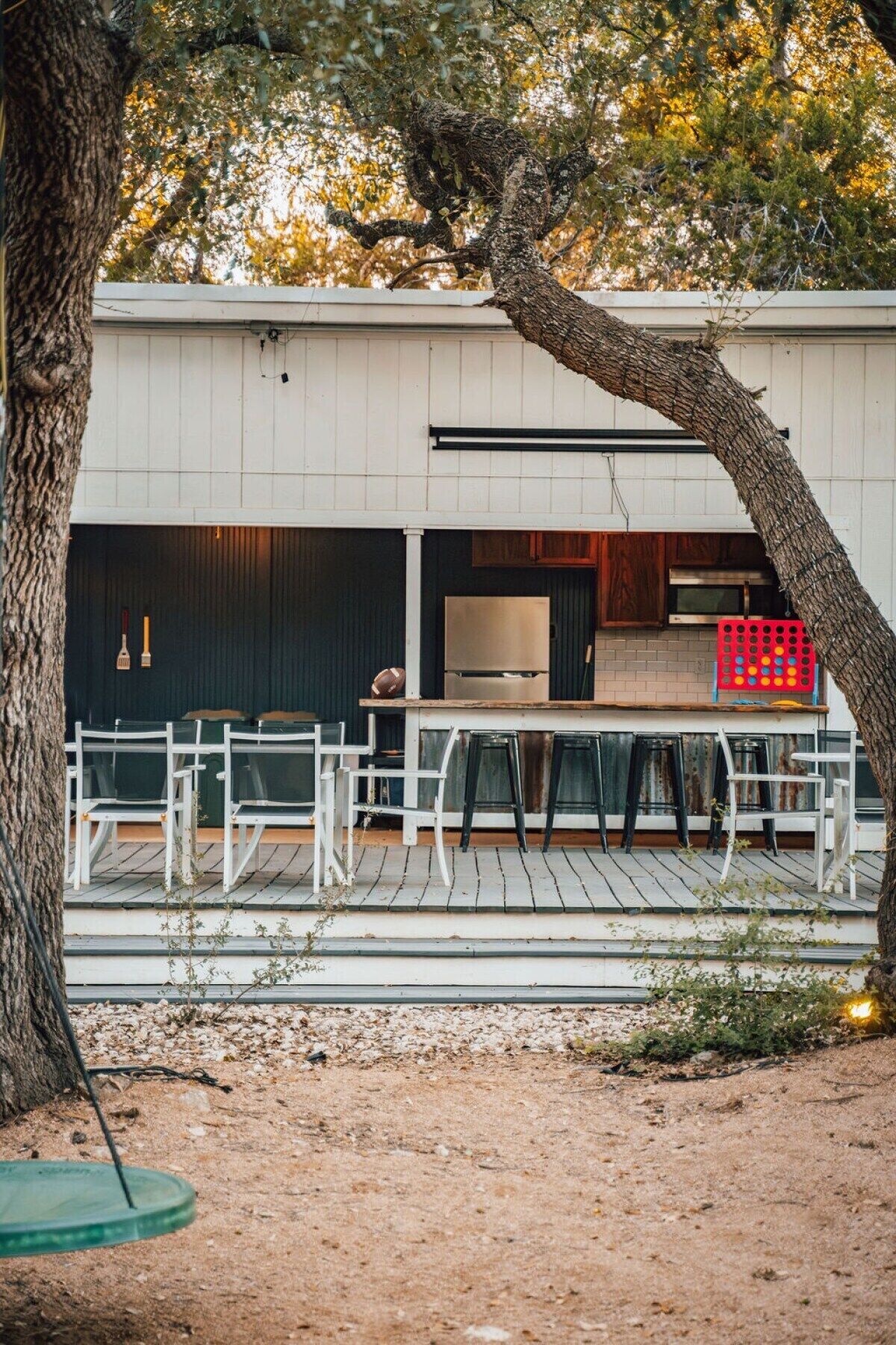 A house with a deck, outdoor seating, and a grill.