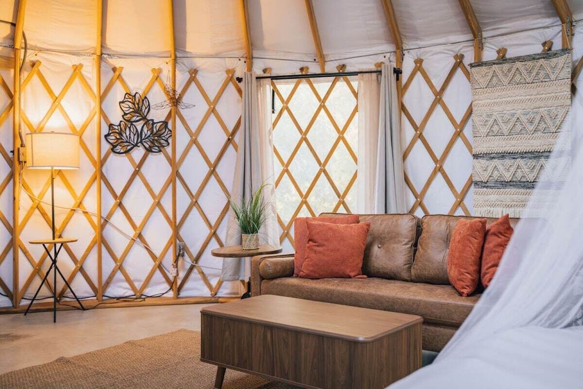 Ein gemütliches Interieur mit einer Couch, einem kleinen Tisch und einer Lampe.