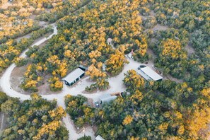 Vista aérea de una propiedad con varias edificaciones rodeadas de un bosque denso.