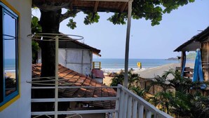 A beachside property with a balcony overlooking the sea, a tree providing shade, and a view of the beach. - Columbus goa  (Canacona)