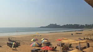 A beach with umbrellas, chairs, and boats. - Columbus goa  (Canacona)