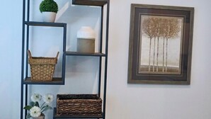 A tall, black metal shelving unit with baskets and a potted plant on the lower shelves. - Spacious 4-bedroom townhome in charming American Fork with AC (American Fork)