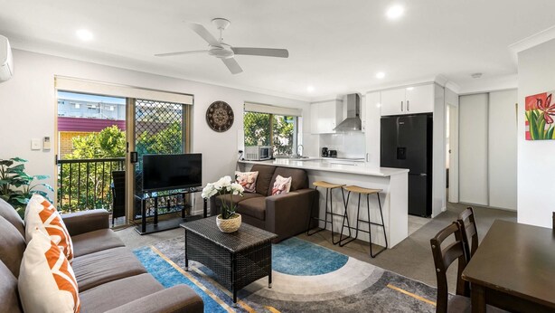 A modern apartment with a living room, kitchen, and dining area. - Charming 3-bed Apartment Near Local Shops (Brisbane)
