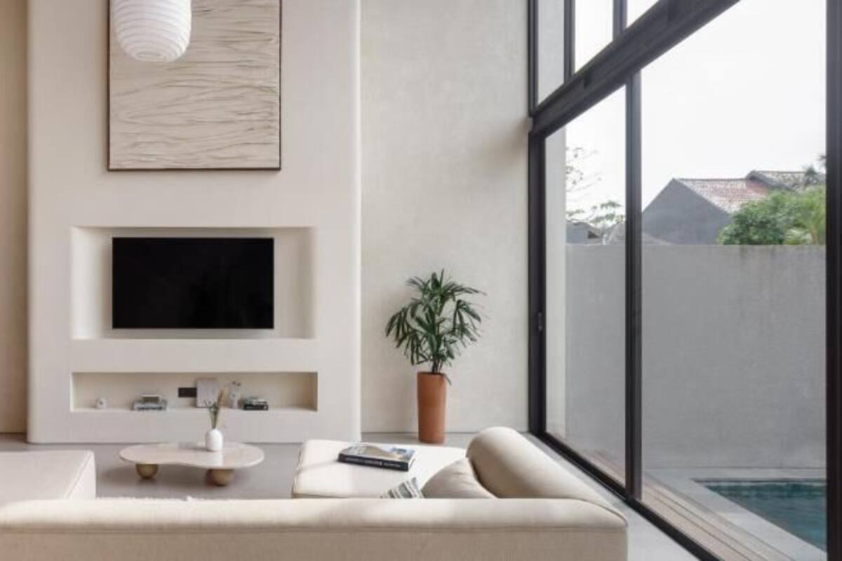 A modern living room with a sofa, coffee table, TV, and a dining area with a table and chairs.
