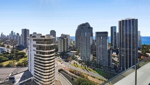 Un hôtel de grande hauteur au design moderne, situé dans une ville offrant une vue sur l’océan.