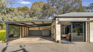 Un bâtiment moderne doté d’un garage fermé, d’un espace patio et d’une grande porte vitrée donnant sur l’intérieur.